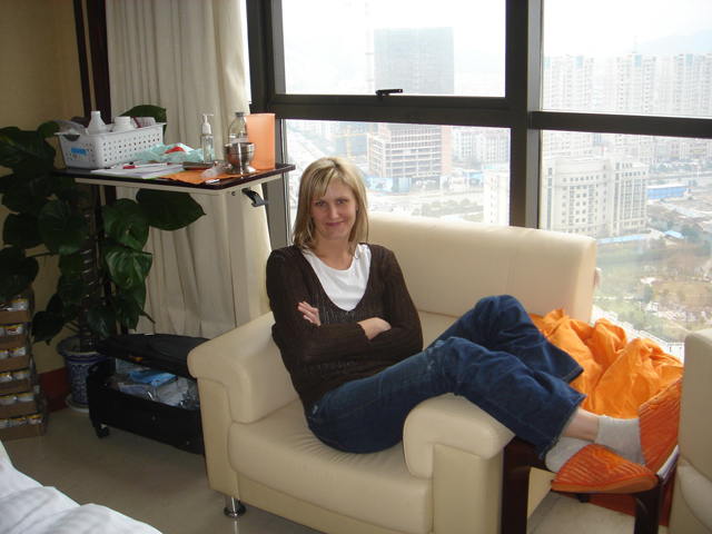 Maria lounging on the 20th floor with the city behind her